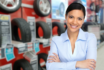 Auto dealer woman near a car tire.