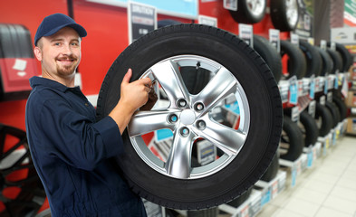 Obraz na płótnie Canvas Car mechanic with a tire.