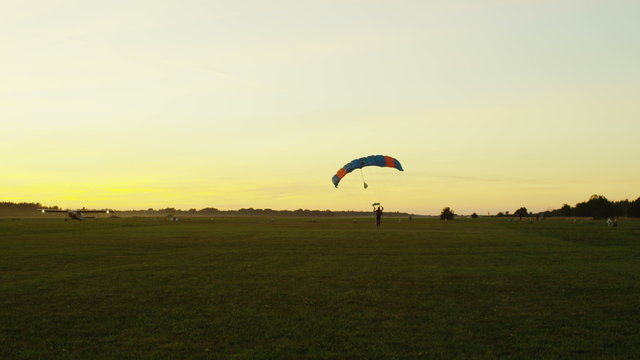 Skydivers are Landing at Sunset