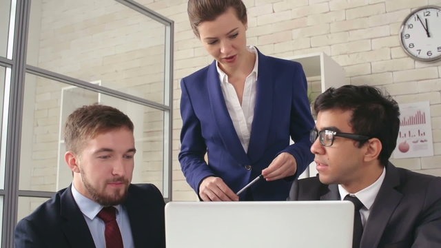 Woman explaining to her business team what they need to correct in report