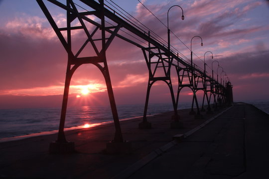 Beautiful bridge and lighthouse over the sunset.