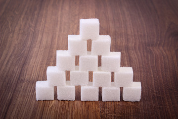 Cubes of sugar on wooden background, ingredient for cooking