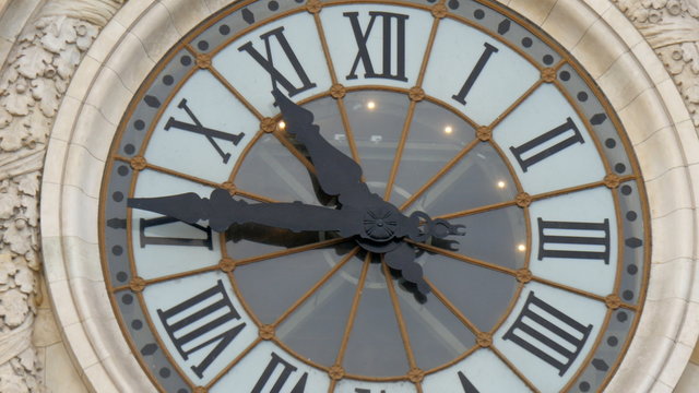 The big wall clock on a building in Paris. The old style clock on the wall of a building