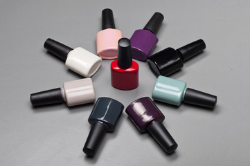 Fototapeta premium Coloured nail polish bottles stacked circle