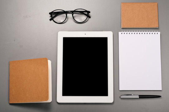 Tablet computer with a notebook, pen and glasses