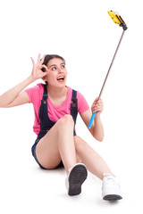 Young woman taking picture with smartphone selfie stick