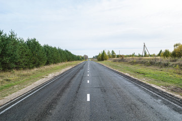 Suburban asphalt highway with white intermittent markings