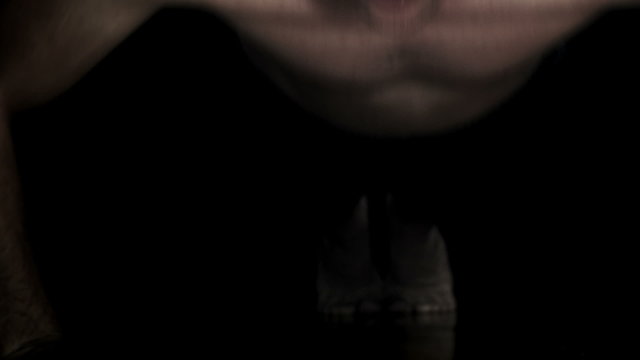 Panning video of a Man doing Push-ups isolated on a black Background