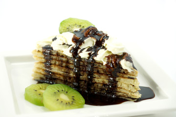 Fresh homemade crepes on plate with kiwi and chocolate