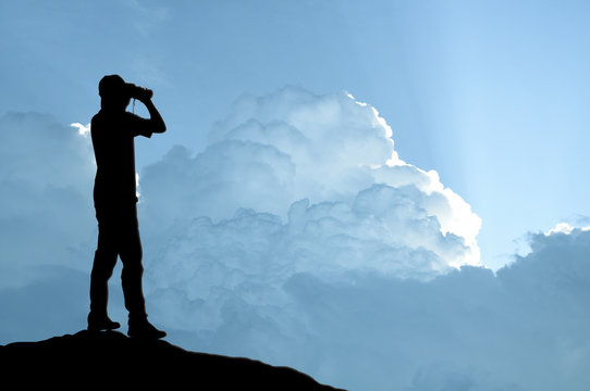 Man holding binocular on sunlight background