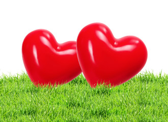 Red hearts on green grass background