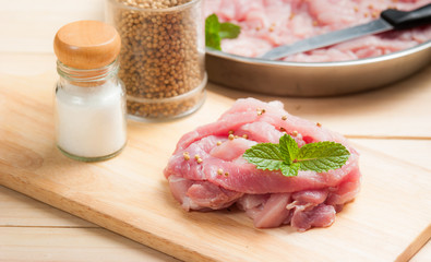 fresh raw pork with spices on cutting board
