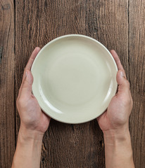 Top view of hand hold a empty bowl on wood