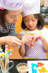 Mother and daughter making jelly candy in ktichen