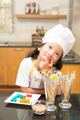 Little girl chef enjoy making jelly candy in kitchen