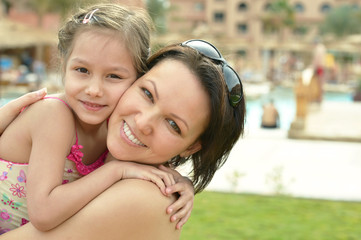 Mother with daughter  near pool