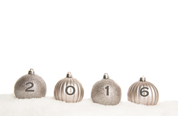 Silver christmas ball ornaments lying on snow on a white background with 2016 on the balls