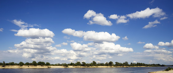 White clouds above the river .