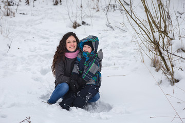 Fototapeta na wymiar Mom and son in the winter forest.