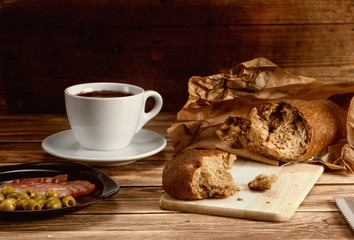 Breakfast with bread , a snack and a cup of coffee.