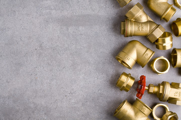 Brass fittings on raw floor background.