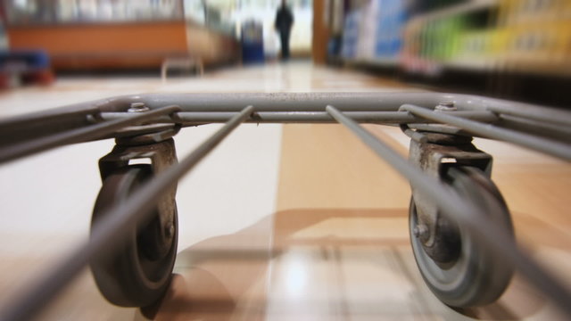 Detail of the Wheels of a Grocery Store Cart Moving inside the Super Market