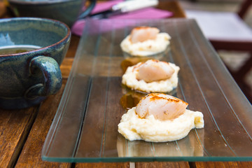 Close up of pan seared sea scallops and a cup of cider