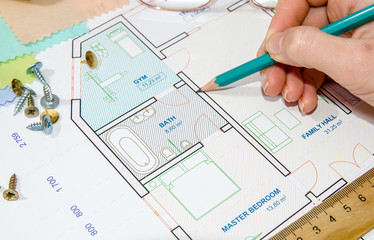 Hand of designer drawing the apartment, view from above