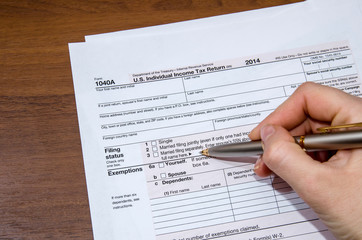 Woman hand filling income tax forms 1040