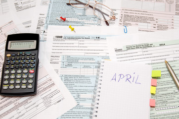 Tax forms with pen, calculator, glasses