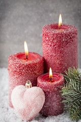 Obraz na płótnie Canvas Three red candles on gray background, Christmas decoration. Adve