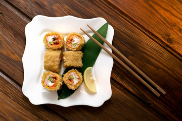 Serving Japanese sushi (rolls), breaded seafood and avocado