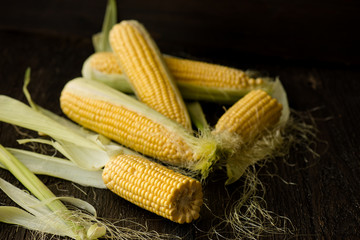 Organic sweet corn on wooden table. Selective focus.