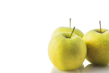composition of three biological yellow apples on white background