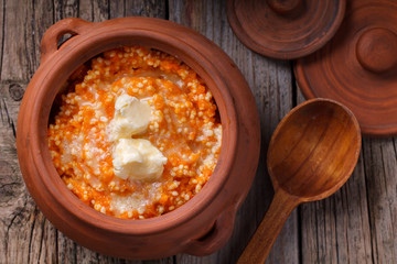 Millet porridge with pumpkin and milk in a clay pot