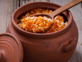Millet porridge with pumpkin and milk in a clay pot