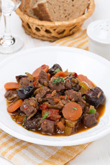 Stew with beef and vegetables on the plate, close-up