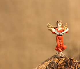 angel statue and the written GLORIA symbol of peace