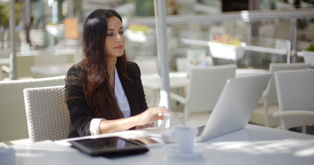 Businesswoman working at an open-air table