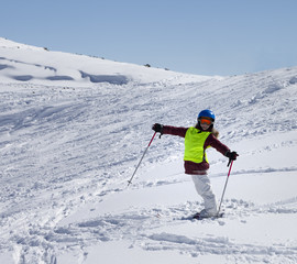 Fototapeta na wymiar Little skier on ski slope with new fallen snow at sun day