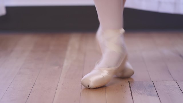 Close up of a ballet dancer's shoes as she does small jumps