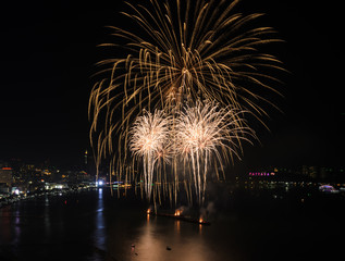 Big yellow fireworks on the sky at Pattaya beach, Thailand