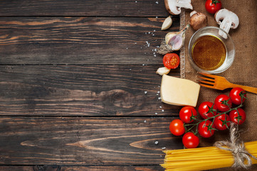 Pasta, tomatoes and mushrooms on wooden table background with copy space