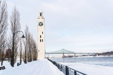 dock clock of the old port of montreal under the snow during a sunny day of winter canada