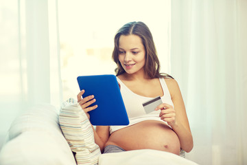 pregnant woman with tablet pc and credit card