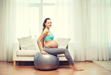 Fototapeta na wymiar happy pregnant woman exercising on fitball at home
