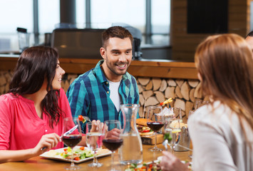 happy friends having dinner at restaurant