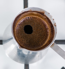 Close-up of brewing coffee in the turk. shallow DOF