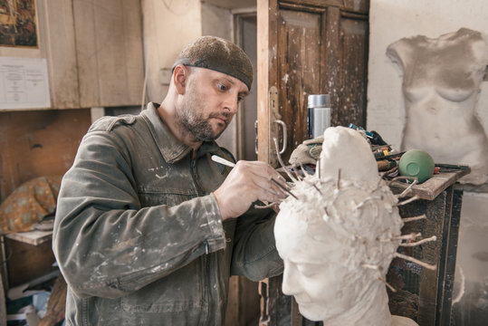 Sculptor man working in his workshop