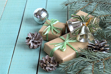 Gifts on Christmas in boxes and Christmas tree branch with pine cones.
